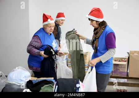 Non esclusiva: IVANO-FRANKIVSK, UCRAINA - 21 DICEMBRE 2022 - i volontari piegano i vestiti al centro aiuti 'Comunità di Sant'Egidio' dove i cittadini possono Foto Stock