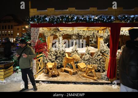 Stalla con cavalli giocattolo in legno (slitta e tira cavalli giocattolo) e alberi X-mas su un mercatino di Natale a Varsavia, Polonia Foto Stock