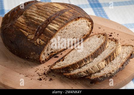 Tradizionale Eifler Brot tedesco intero, pane tedesco, e fette di primo piano su un tagliere Foto Stock