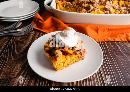 Casseruola di toast alla zucca con panna montata: Fetta di zucca casseruola di toast alla francese servita su un piatto Foto Stock