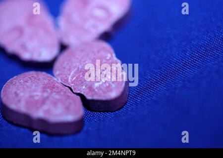 Rosa cranio ecstasy pillola primo piano sfondo alta qualità stampe viola esercito drogato narcotici sostanza psicedelica ad alta dose modo di vita Foto Stock