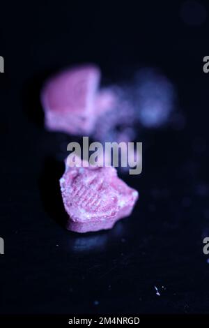 Rosa cranio ecstasy pillola primo piano sfondo alta qualità stampe viola esercito drogato narcotici sostanza psicedelica ad alta dose modo di vita Foto Stock