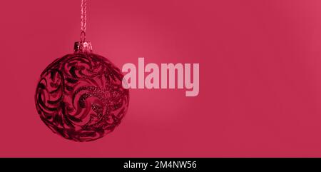 Pallina di Natale magenta su sfondo magenta. Colore dell'anno 2023 Viva Magenta Foto Stock