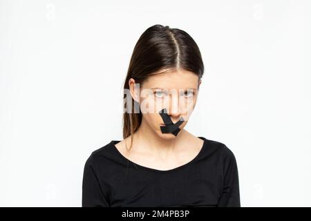 Ragazza con la bocca sigillata su sfondo isolato, mantenere tranquilla e non dire nulla, segreto Foto Stock