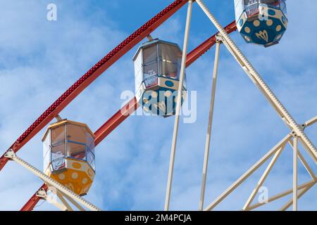 Colorate cabine ruota ferris vista ravvicinata nel parco centrale, città di Kharkiv. Attrazioni di divertimento dettagli sul cielo blu Foto Stock