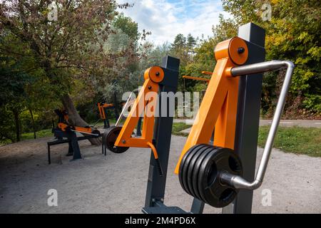 Campo sportivo all'aperto con attrezzature per l'allenamento pesi nel parco cittadino. Area fitness nell'area ricreativa verde Foto Stock