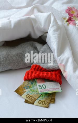 Banconote in giacenza sotto piumino, stoccaggio risparmio, franco svizzero Foto Stock