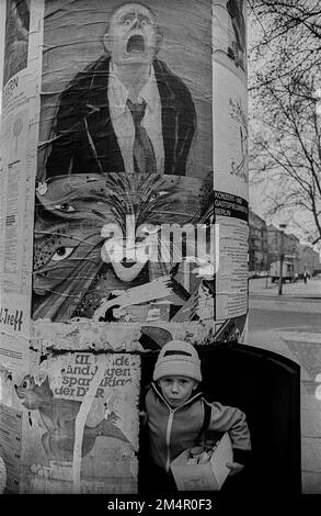 GDR, Berlino, 18. 03. 1989, bambino in una colonna pubblicitaria, manifesti, Kollwitzplatz Foto Stock