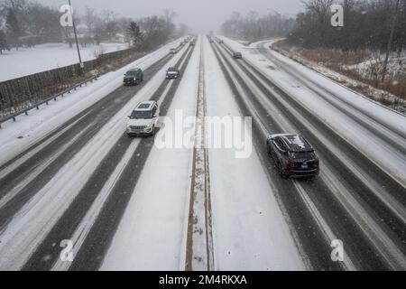 Chicago, Stati Uniti. 22 dicembre 2022. Tempo di Chicago: Il traffico passa come nevicate pesanti comincia in un sobborgo occidentale di Chicago come una tempesta invernale arriva nel Midwest. Le temperature sono attualmente -16C, ma il freddo del vento sembra -21C. Si prevede che le condizioni peggioreranno ulteriormente, trasformandosi in un cosiddetto “ciclone bomba”, che garantisce a molti un Natale bianco. Credit: Stephen Chung / Alamy Live News Foto Stock