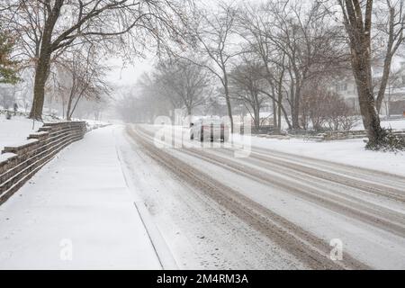 Chicago, Stati Uniti. 22 dicembre 2022. Tempo di Chicago: Il traffico passa come nevicate pesanti comincia in un sobborgo occidentale di Chicago come una tempesta invernale arriva nel Midwest. Le temperature sono attualmente -16C, ma il freddo del vento sembra -21C. Si prevede che le condizioni peggioreranno ulteriormente, trasformandosi in un cosiddetto “ciclone bomba”, che garantisce a molti un Natale bianco. Credit: Stephen Chung / Alamy Live News Foto Stock