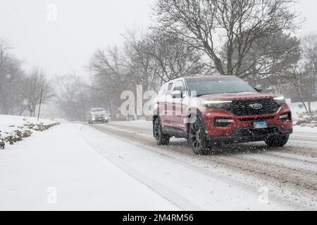 Chicago, Stati Uniti. 22 dicembre 2022. Tempo di Chicago: Il traffico passa come nevicate pesanti comincia in un sobborgo occidentale di Chicago come una tempesta invernale arriva nel Midwest. Le temperature sono attualmente -16C, ma il freddo del vento sembra -21C. Si prevede che le condizioni peggioreranno ulteriormente, trasformandosi in un cosiddetto “ciclone bomba”, che garantisce a molti un Natale bianco. Credit: Stephen Chung / Alamy Live News Foto Stock