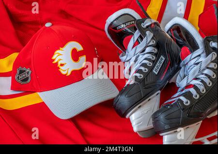 Calgary, Alberta - 22 dicembre 2022: Cappellino da baseball e maglia della squadra NHL C Calgary Flames con i pattini Bauer. Foto Stock