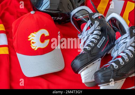 Calgary, Alberta - 22 dicembre 2022: Cappellino da baseball e maglia della squadra NHL C Calgary Flames con i pattini Bauer. Foto Stock