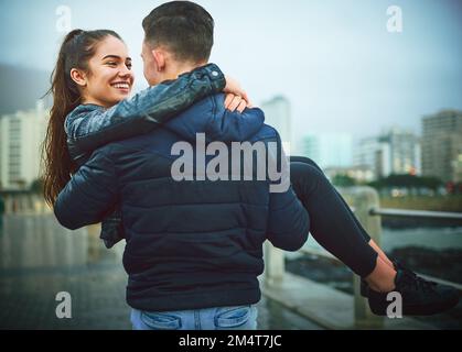 Il mio eroe. un giovane uomo che porta romanticamente la sua ragazza all'aperto. Foto Stock