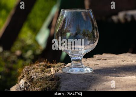 un calice di vetro trasparente vuoto si trova a terra Foto Stock