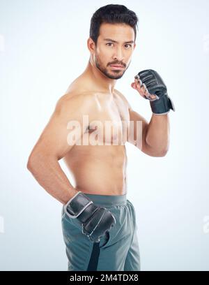 Ritratto facciale, sport mma e uomo in studio su sfondo blu. Arti marziali, fitness corpo e combattente maschile serio o pugile pronto per l'allenamento Foto Stock