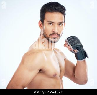 Ritratto facciale, sport mma e uomo in studio su sfondo blu. Arti marziali, fitness corpo e combattente maschile serio o pugile pronto per l'allenamento Foto Stock