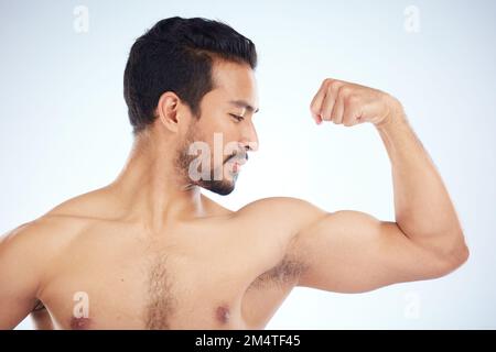 Uomo asiatico, corpo di bicep flex su sfondo studio in studio per il progresso della crescita muscolare, salute controllo benessere o bodybuilding successo. Sport Foto Stock
