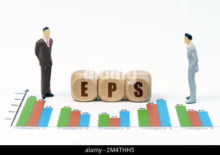 Concetto di business e finanza. Su relazioni finanziarie con grafici, una figura di uomini d'affari e cubi di legno con l'iscrizione - EPS Foto Stock