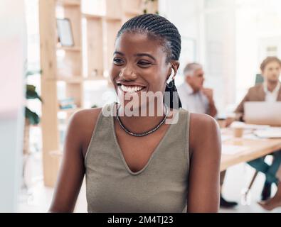 Musica, podcast e donna al computer con auricolari in ufficio con servizio di streaming mentre lavora. Lavoro, sorriso e felice donna nera che ascolta Foto Stock