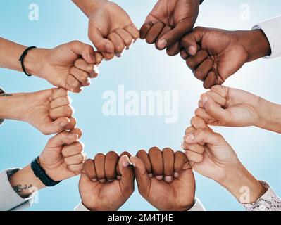 Mani di pugno, cerchio e lavoro di squadra di uomini d'affari per la costruzione di team con angolo basso all'aperto. Cielo blu, collaborazione e sostegno, unità o Unione di Foto Stock