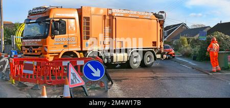 Cabina vuota camion autocarro lentamente inversione aspirazione macchina di scavo hgv conducente in piedi in una tranquilla strada residenziale utilizzando il telecomando portatile UK Foto Stock