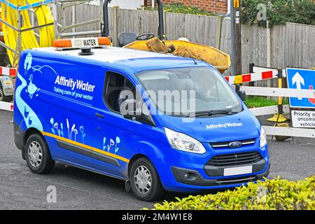 Vista laterale e frontale Affinity Water supply Company business Ford van in strada residenziale guida passato gas principale sostituzione strada lavori Essex Inghilterra UK Foto Stock