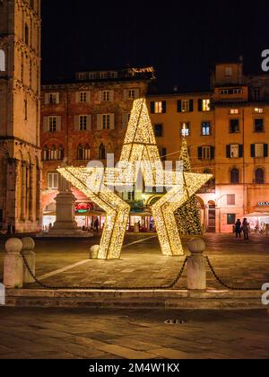 Natale a Lucca. Una stella e un albero di Natale gigante nella bella Piazza San Michele Foto Stock