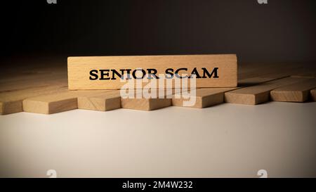 Parola truffa senior. Log di fondo scritto su telaio di legno Foto Stock