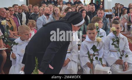 Pervomaysk, Bielorussia - 17 giugno 2022: Bambini in chiesa alla loro prima comunione cattolica. Foto Stock