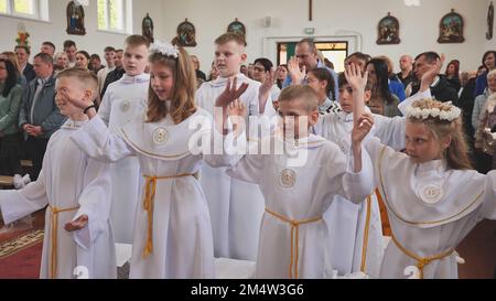 Pervomaysk, Bielorussia - 17 giugno 2022: I bambini cantano alla loro prima comunione cattolica. Foto Stock