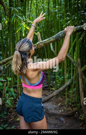 Ritratto di una giovane donna caucasica in un tour escursionistico in una foresta sull'isola o'ahu, Hawaii Foto Stock