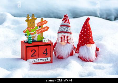 Calendario cubo con data 24 dicembre, gnomi scandinavi e decorazioni natalizie nella foresta innevata Natale biglietto di Natale data di Natale. Foto Stock