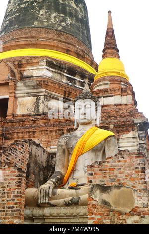 Splendida statua del Buddha in veste gialla presso l'antico tempio di Wat Yai Chai Mongkhon, Ayutthaya Historical Park, Thailandia Foto Stock