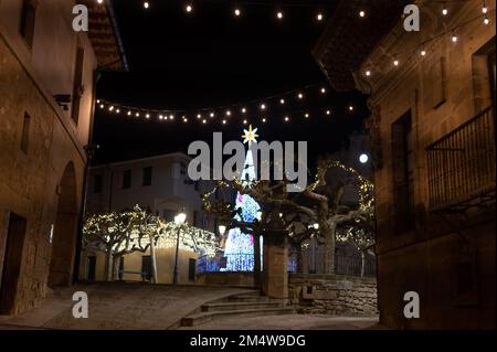 Camminando di notte sulle vecchie stradine medievali del villaggio di Elciego illuminato dalle luci di Natale, Rioja Alavesa, Spagna Foto Stock