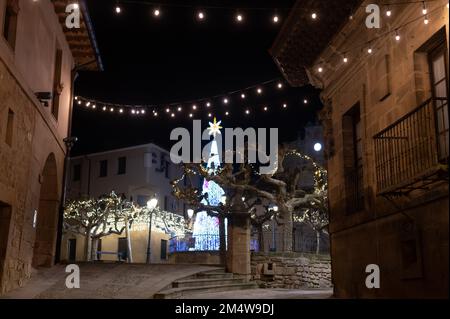 Camminando di notte sulle vecchie stradine medievali del villaggio di Elciego illuminato dalle luci di Natale, Rioja Alavesa, Spagna Foto Stock