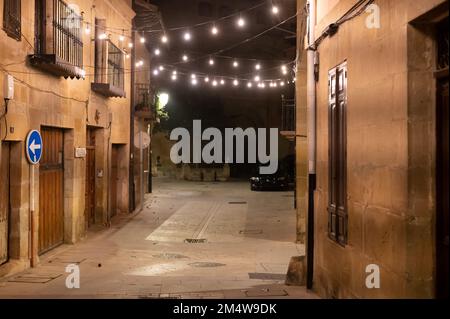 Camminando di notte sulle vecchie stradine medievali del villaggio di Elciego illuminato dalle luci di Natale, Rioja Alavesa, Spagna Foto Stock