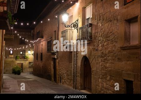 Camminando di notte sulle vecchie stradine medievali del villaggio di Elciego illuminato dalle luci di Natale, Rioja Alavesa, Spagna Foto Stock