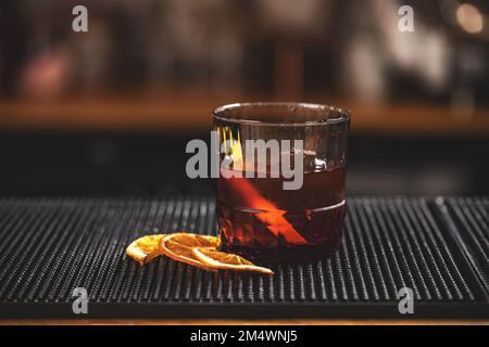Classico cocktail negroni in vetro retrò con ghiaccio e arancia Foto Stock