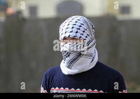 Nablus, Palestina. 23rd Dec, 2022. Un manifestante palestinese mascherato ha visto, durante la manifestazione contro gli insediamenti israeliani nel villaggio di Kafr Gheddaum vicino alla città di Nablus in Cisgiordania. (Foto di Nasser Ishtayeh/SOPA Images/Sipa USA) Credit: Sipa USA/Alamy Live News Foto Stock