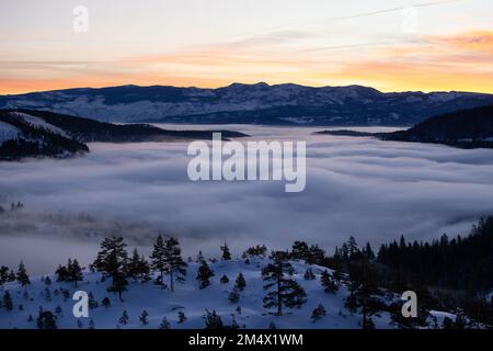 Un'alba nebbiosa sul lago Donner, nelle montagne della Sierra Nevada, California Foto Stock