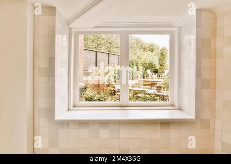 una finestra del bagno con la vista sul giardino dalla sua vasca di fronte alla casa Foto Stock