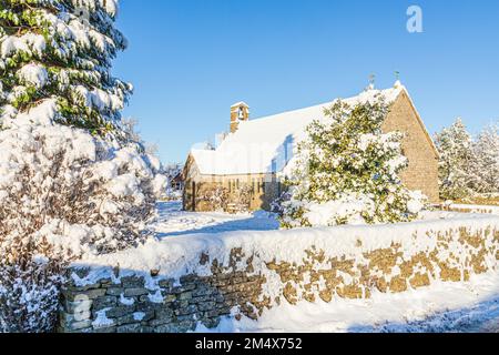 Neve d'inizio inverno sulla piccola chiesa in pietra di St Mary in Hamlet (costruita nel 1958) nel villaggio Cotswold di Birdlip, Gloucestershire, Inghilterra UK Foto Stock