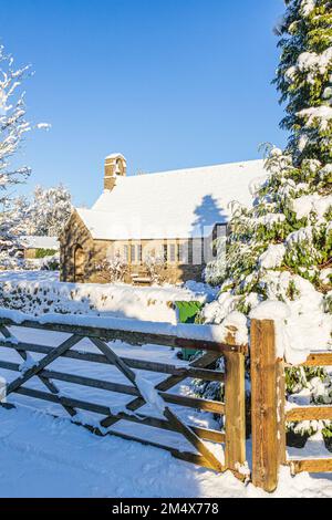 Neve d'inizio inverno sulla piccola chiesa in pietra di St Mary in Hamlet (costruita nel 1958) nel villaggio Cotswold di Birdlip, Gloucestershire, Inghilterra UK Foto Stock