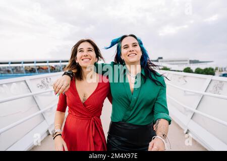 Sorelle che si divertono a camminare sul ponte pedonale Foto Stock