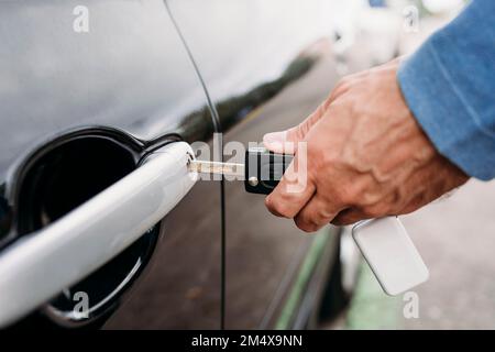 Mano di uomo che blocca l'auto con la chiave Foto Stock