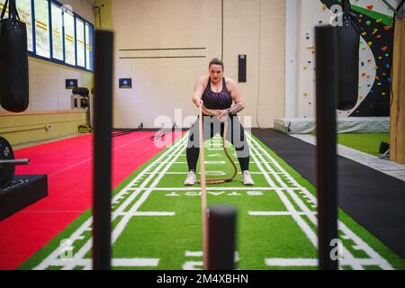 Giovane donna che fa cross training in palestra Foto Stock