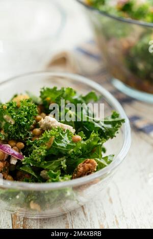 Insalata fatta in casa con kale, lenticchie, olive, noci e feta vegana. Foto Stock