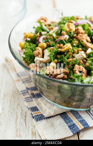 Insalata fatta in casa con kale, lenticchie, olive, noci e feta vegana. Foto Stock