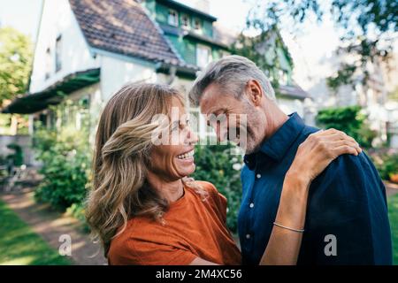 Uomo e donna allegri che trascorrono del tempo insieme nel cortile posteriore Foto Stock